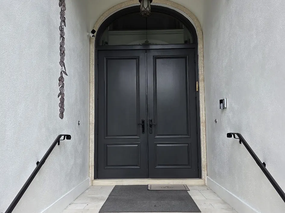 Arched entry with a dark double door and limestone steps