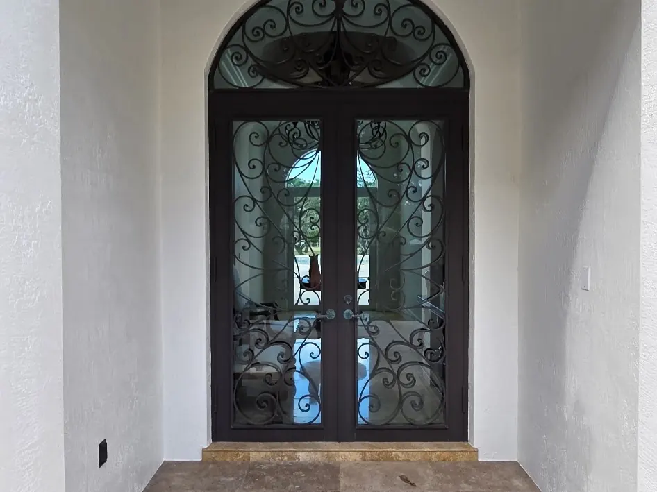 Arched entry with an ornamental iron door