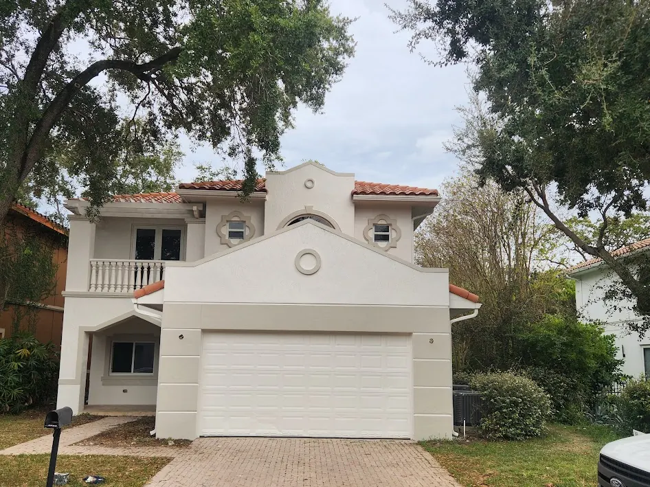 Two-story home with a barrel-tile roof and white garage door