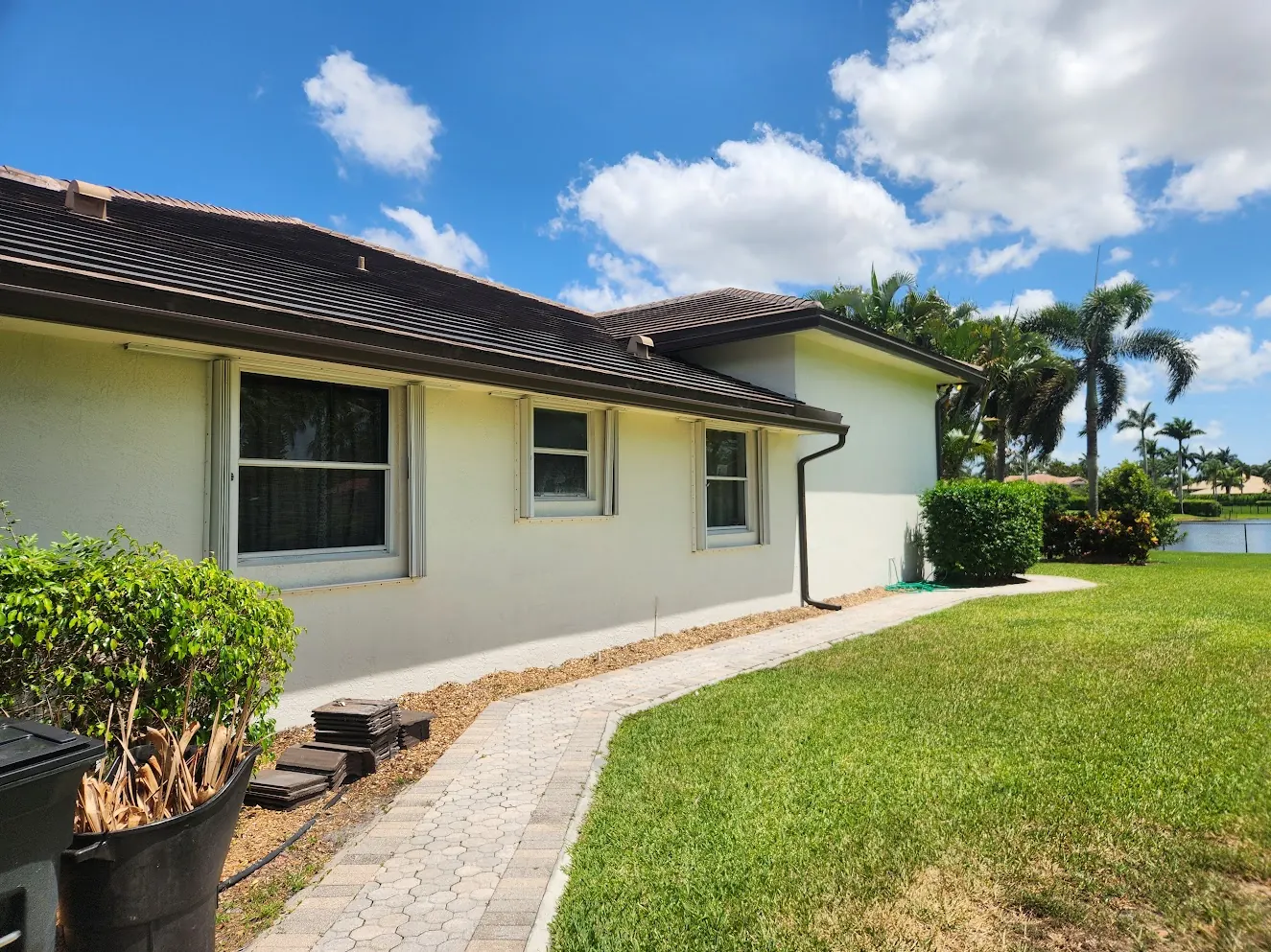 Side elevation of a single-story home with a paver walkway after an exterior repaint