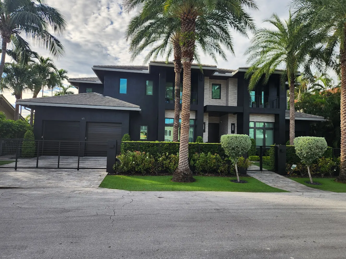 Dark contemporary home with stone accents and palms in Fort Lauderdale after an exterior repaint