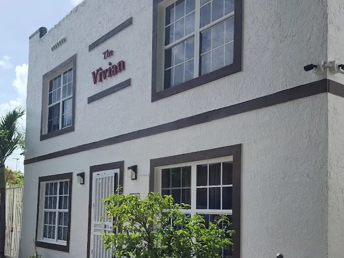 Small white apartment building in Miami with dark trim after an exterior repaint