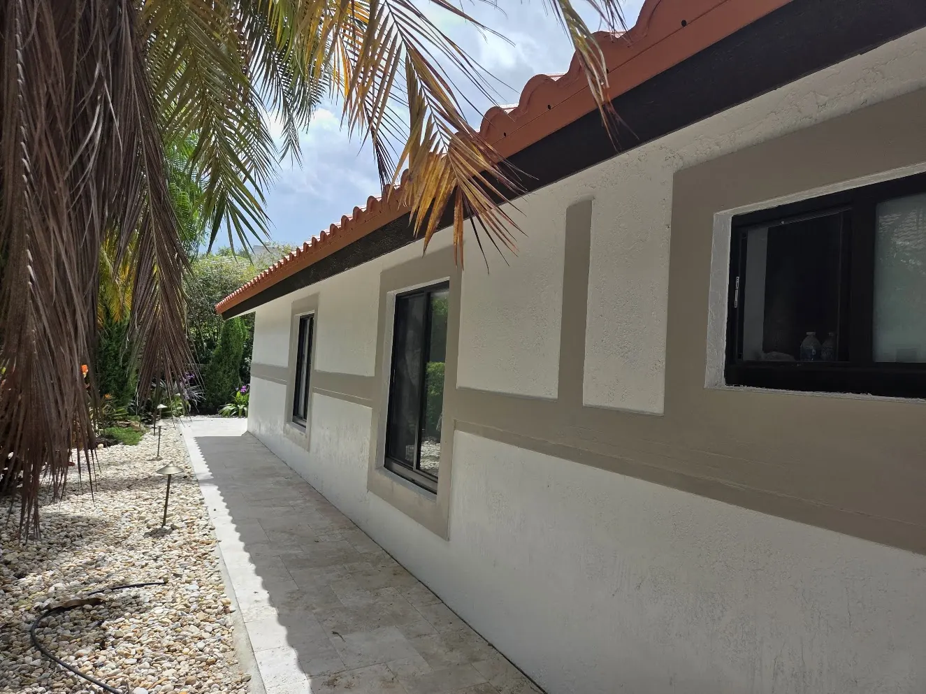 Side elevation of a Weston home with two-tone stucco bands after an exterior repaint