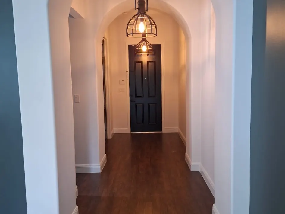 Arched interior hallway with dark blue-grey walls after interior painting