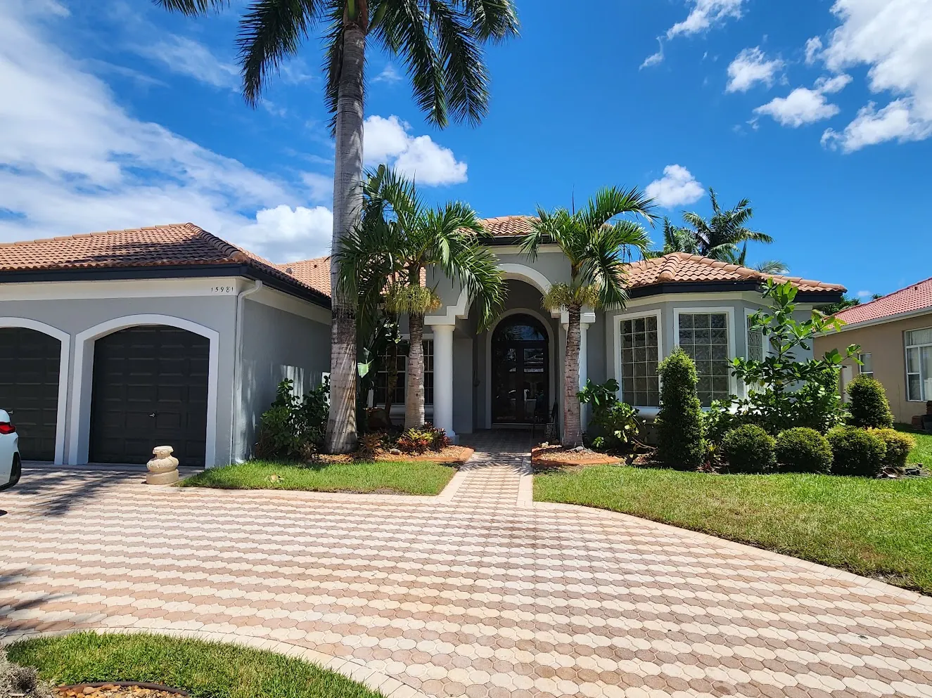 Mediterranean-style Weston home with palms and a paver drive after an exterior repaint