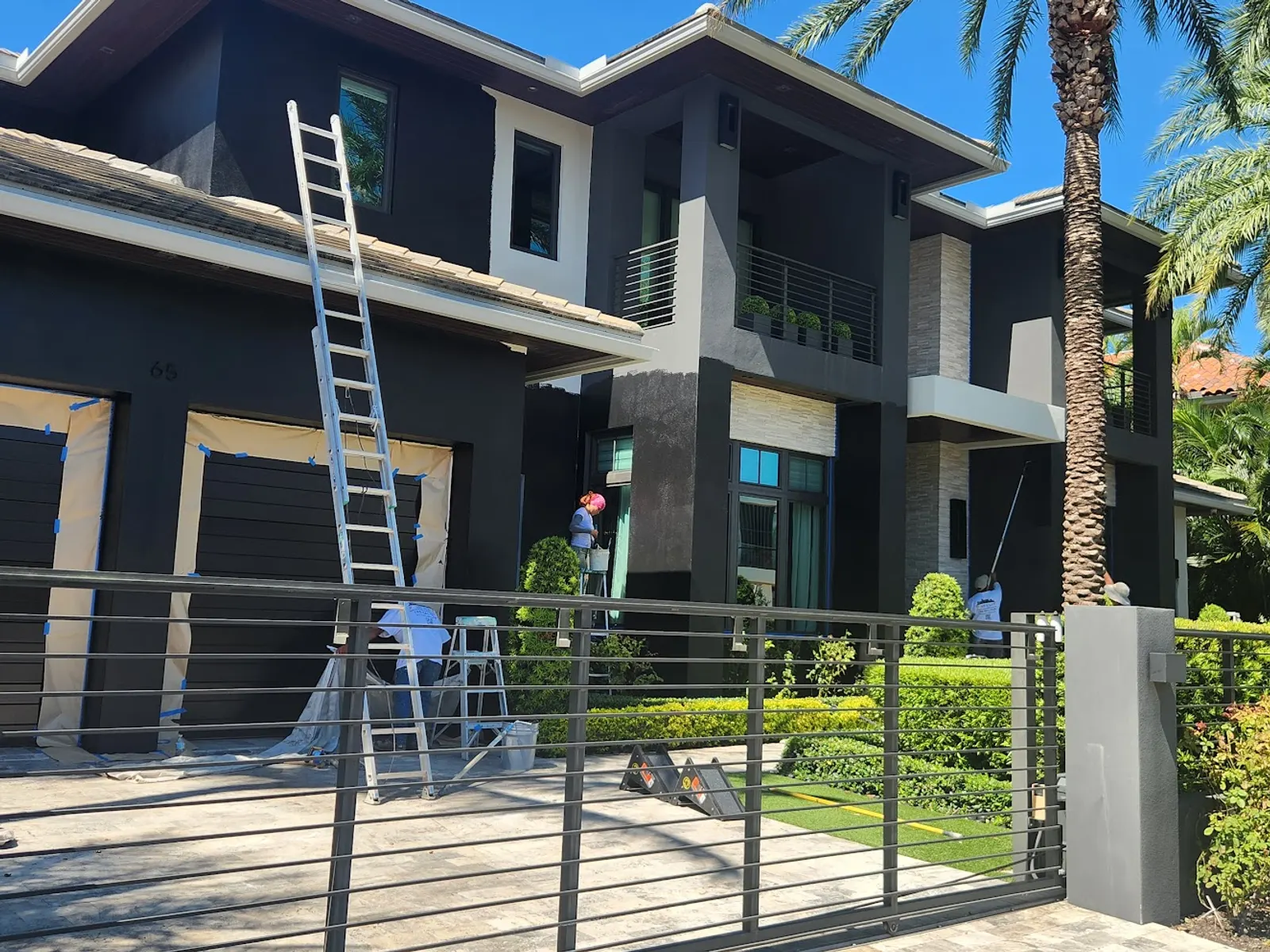 Paint2Last crew on ladders repainting a modern two-story home