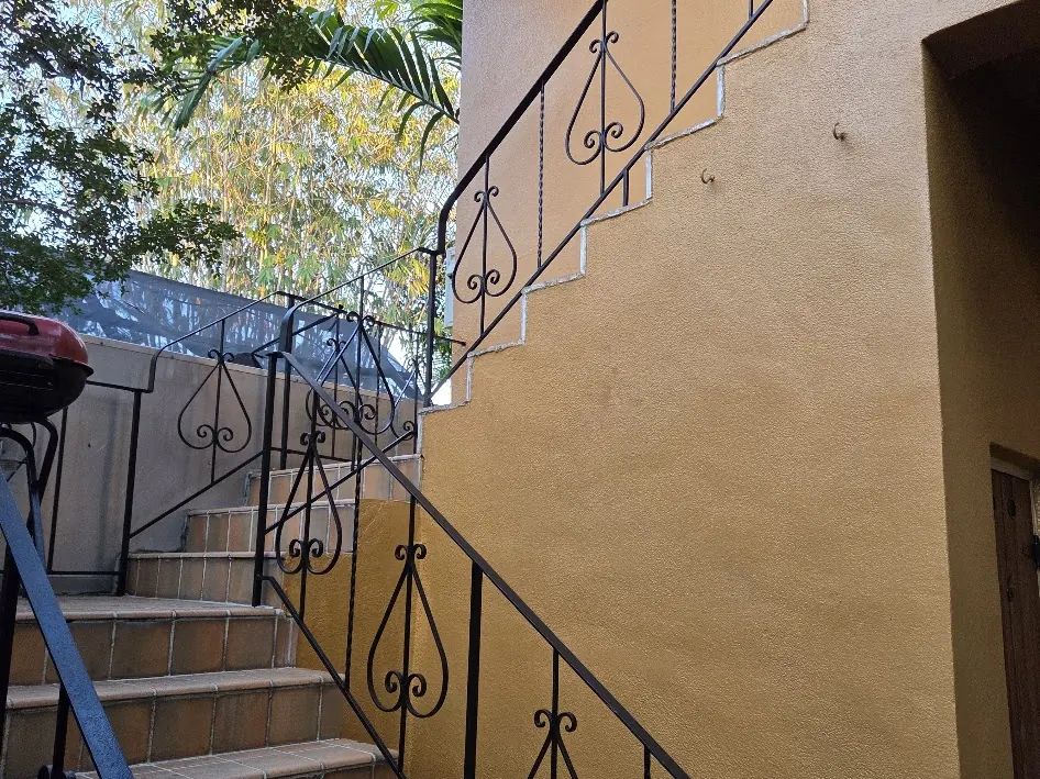 Exterior staircase after work with Tricorn Black railings against Gold Stock walls
